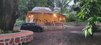 una casita con un coche aparcado delante. en Sukriti Farms, en Kalyan