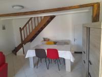 a dining room table with two chairs and a staircase at Gîte Linglet in Fumay