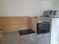 a kitchen with a microwave on top of a stove at Gîte Linglet in Fumay