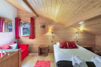 a small room with a bed and a red chair at Casa Linga - Chalet - BO Immobilier in Châtel