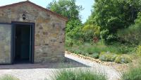 a stone building with a door in a garden at Agricampeggio Madonna di Pogi in Bucine