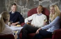 グスタフスベリにあるホテル ブロア ブロームの椅子に座ってワインを飲んでいる人々のグループ