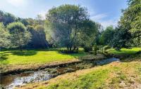 a stream in a field with trees and a river at Beautiful Home In Plouigneau With Kitchen in Plouigneau