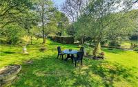 a table and chairs in the grass in a yard at Beautiful Home In Plouigneau With Kitchen in Plouigneau