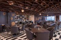 Un restaurante con mesas y sillas sobre un suelo a cuadros. en Wyndham Garden Hanoi, en Hanói