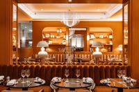 a restaurant with two tables and a large mirror at Sofitel Paris Baltimore Tour Eiffel in Paris