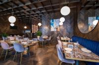 a restaurant with wooden walls and tables and chairs at Tbilisi Philharmonic Hotel by Mercure in Tbilisi City
