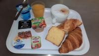 a plate of breakfast food with bread and a cup of coffee at Premiere Classe Orleans Ouest - La Chapelle St Mesmin in La Chapelle-Saint-Mesmin
