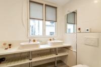 a bathroom with two sinks and two windows at Sweet Inn - Chevalier Saint Georges in Paris