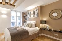 a bedroom with a large bed and a mirror at Sweet Inn - Chevalier Saint Georges in Paris
