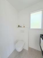 a white bathroom with a toilet and a window at Maison de vacances à Loctudy in Loctudy