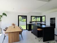 a kitchen with a black island and a wooden table at Maison de vacances à Loctudy in Loctudy