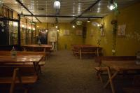 un comedor con mesas de madera y paredes amarillas en Rann Meadows Ranthambhore, en Sawāi Mādhopur