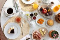 a table with plates of food and cups of coffee at La Bastide Bourrelly - Mathias Dandine in Cabriès