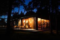 a house lit up at night with lights at Lovely apartment by the sea. in Ķesterciems