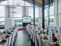 オーケシュバーリアにあるSkåvsjöholm, hotell & konferensのテーブルと白い椅子が備わる宴会場