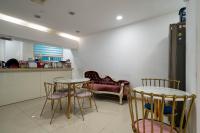 a kitchen with two tables and chairs and a couch at Pacific7 Hotel in Pyeongtaek