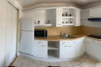 La cuisine est équipée de placards blancs et d&#39;un réfrigérateur blanc. dans l&#39;établissement Appartement F2 hyper centre, à Lacroix-Saint-Ouen
