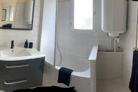 La salle de bains est pourvue d&#39;une douche, d&#39;un lavabo et d&#39;une baignoire. dans l&#39;établissement Appartement F2 hyper centre, à Lacroix-Saint-Ouen