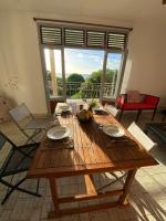 a wooden table in a room with a large window at Télétravail et Plaisir au soleil avec vue mer! in Bouillante