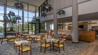 a restaurant with tables and chairs and large windows at Holiday Inn - Nairobi Two Rivers Mall by IHG in Nairobi