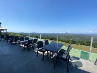 Un patio con mesas y sillas en un balcón. en Tranquil Park, en Maleny