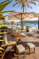 a patio with tables and chairs and an umbrella at ERTAN OTEL in Cesme
