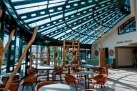 een kamer met tafels en stoelen en een glazen plafond bij Hotel Amadeus Frankfurt in Frankfurt am Main