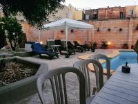 a patio with chairs and a table and an umbrella at Double bedroom with shared bathroom, NO KITCHEN in Msida