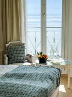 Un dormitorio con una cama y una mesa y una ventana. en Hotel Eden Palace au Lac, en Montreux