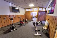 a gym with several exercise bikes and a flat screen tv at Hotel Tanne in Saalfeld