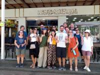a group of people posing for a picture in front of a store at apartment between ajloun castle and Jerash ruins in Jerash