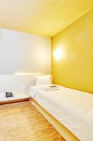 a bedroom with a white bed and a yellow wall at Single Inn - Taipei in Taipei