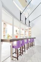 a long table with purple chairs in a room with windows at Single Inn - Taipei in Taipei