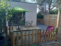 a patio with a table and a green umbrella at Au ptit Manoir in Montbert