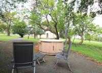 two chairs and a wooden tub in a park at L&#39;Atelier à l&#39;orée des bois in Saint-Pierre-sur-Dives