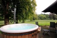 a hot tub in a yard with a table and chairs at L&#39;Atelier à l&#39;orée des bois in Saint-Pierre-sur-Dives