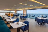 Un restaurante con mesas y sillas y el océano. en Radisson Hotel Colombo, en Colombo