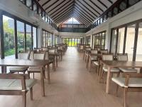 een eetkamer met tafels en stoelen en ramen bij Sumator Resort Chiangrai สูมาเต๊อะ รีสอร์ท เชียงราย in Ban Huai Phaya Kao