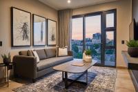 ヨハネスブルグにあるThe Catalyst Apartment Hotel by NEWMARKのソファとテーブルのあるリビングルーム