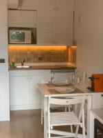 a kitchen with white cabinets and a table and a sink at Bleuets II in Sainte-Léocadie
