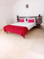 a bedroom with a large bed with a red blanket on it at Domaine de kerbillec in Theix