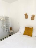 a bedroom with a white bed with a yellow pillow at Appartement terrasse proche Centre in Montpellier