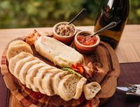 a plate of food with bread and dip and a bottle of wine at Pipas Terroir & Domos Perlage - Experiências Únicas no Vale dos Vinhedos in Bento Gonçalves