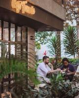 dois homens sentados à mesa do lado de fora de um prédio em Apartamento Lauret en Laureles em Medellín