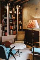 een woonkamer met een tafel, stoelen en boekenplanken bij La Planque en Perche in Bellou-le-Trichard