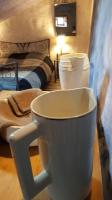 a white coffee cup sitting on a table in a room at Les papillons in Agnat