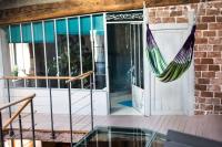 a porch with a hammock next to a door at Les papillons in Agnat