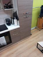 a kitchen with wooden cabinets and a refrigerator at STUDIO AVEC TERRASSE DONNANT SUR UN PARC ABORE in Bourg-en-Bresse