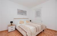 a white bedroom with a bed and a window at Cozy Home In Makarska With Kitchen in Makarska